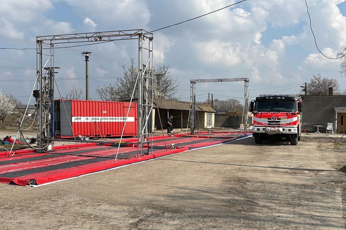 Hasiči staví dekontaminační rohože.jpg