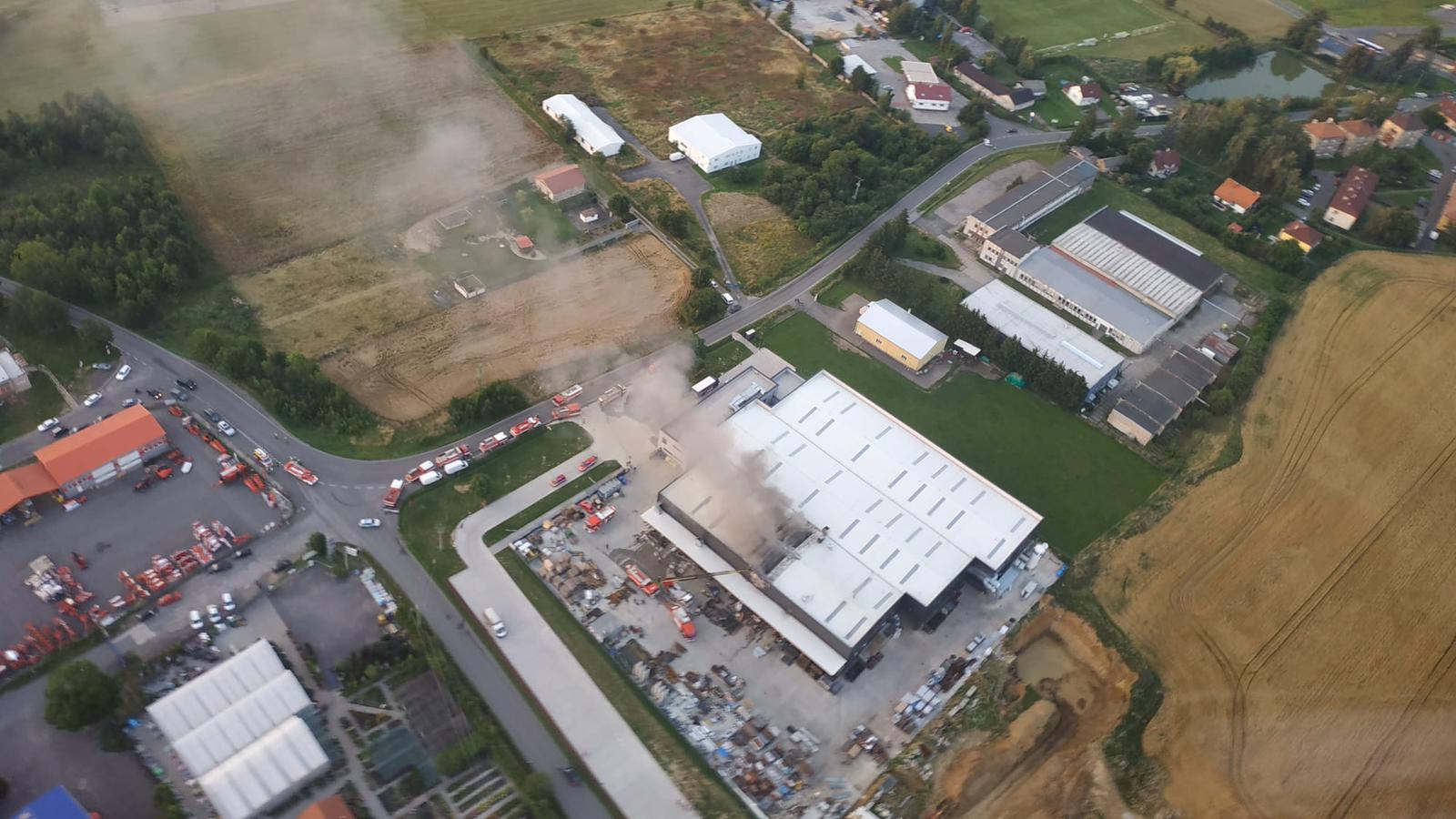 SČK_Požár hořovické lakovny_pohled z dronu na průmyslový areál a zasahující hasičskou techniku.jpg